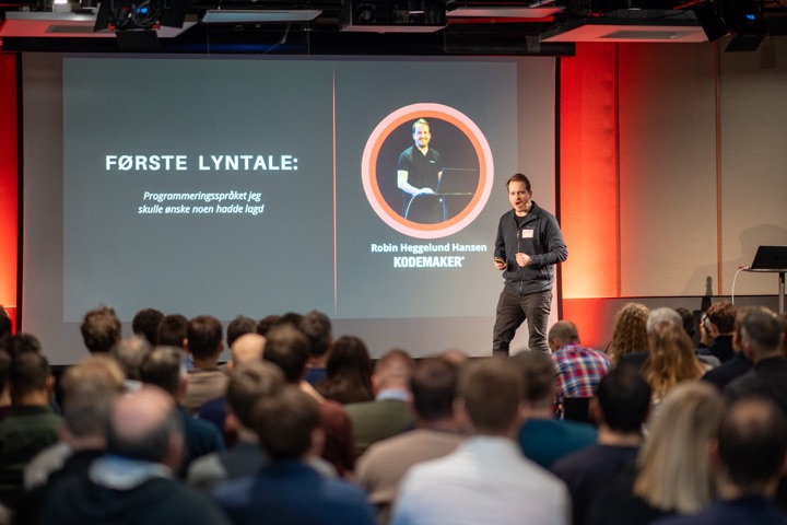 Publikum følger første lyntale i en fullsatt sal.